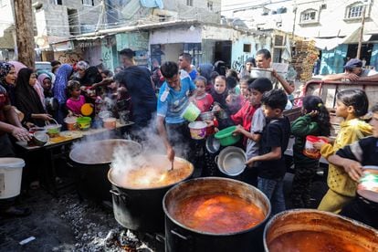 Un grupo de palestinos reciben alimentos en Rafah, al sur de la Franja.
